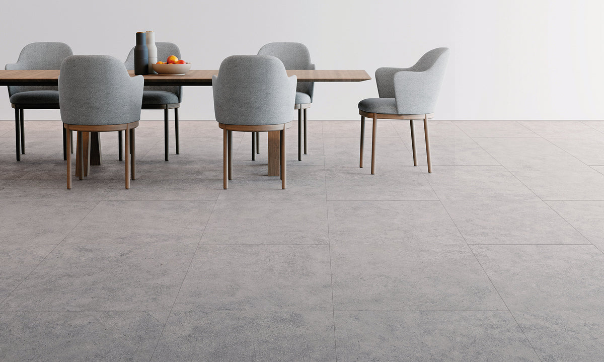 Eetkamer met grijze tegellook vloer in betonsteen en lichtgrijze stoelen