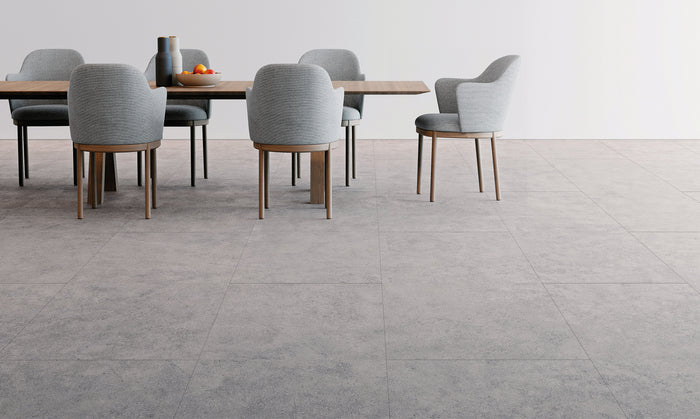 Eetkamer met grijze tegellook vloer in betonsteen en lichtgrijze stoelen